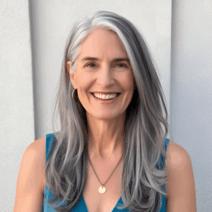 Smiling woman with long gray hair.